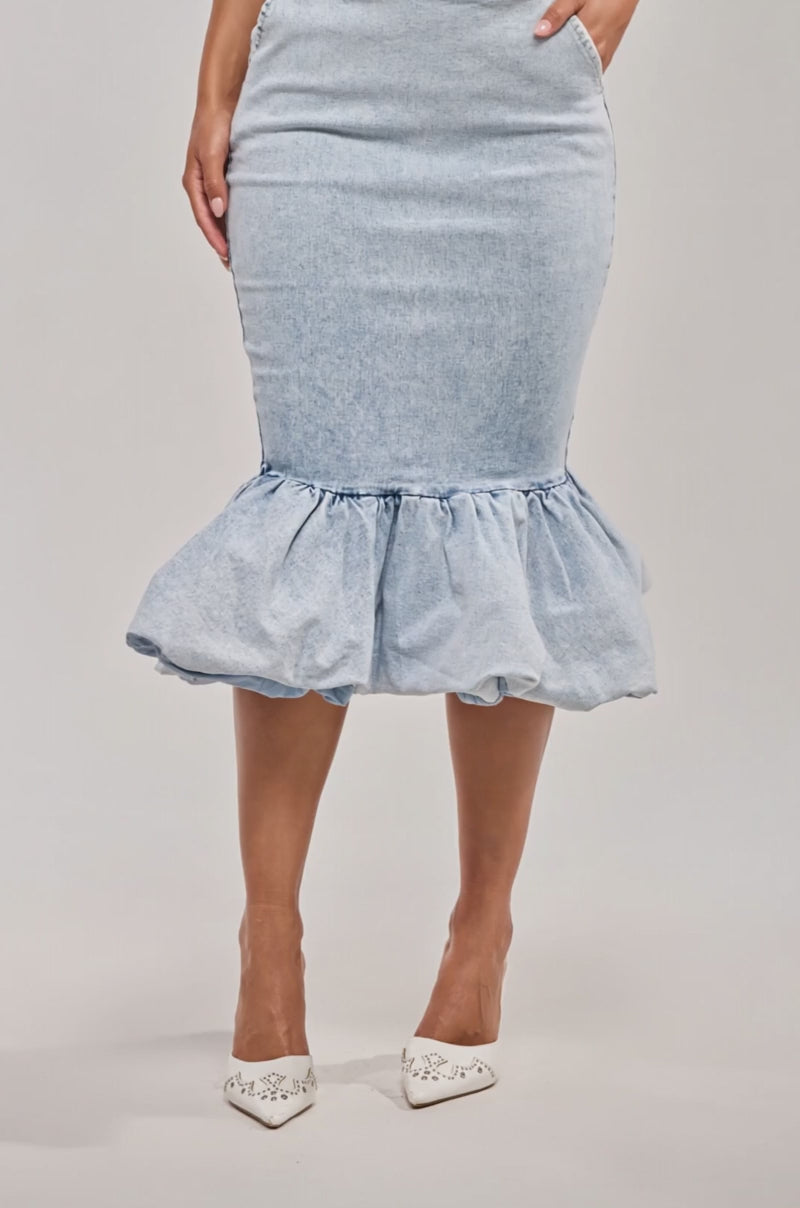 Video of woman modeling the LOVE ME LIKE THAT DENIM MIDI SKIRT—a light blue, high-rise waist midi skirt with a ruffled hem and side pockets