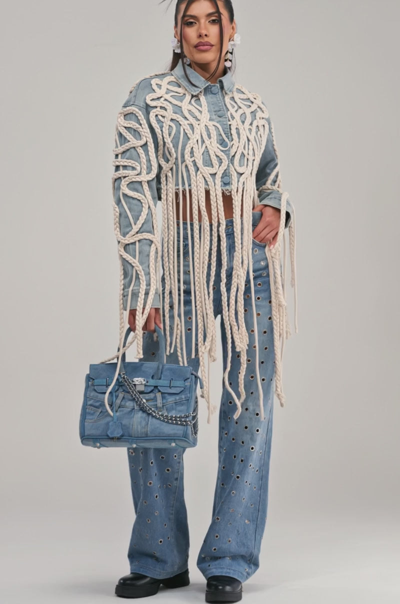 Video of a woman modeling the KEEP MOVING TASSEL DENIM JACKET with rope detailing.