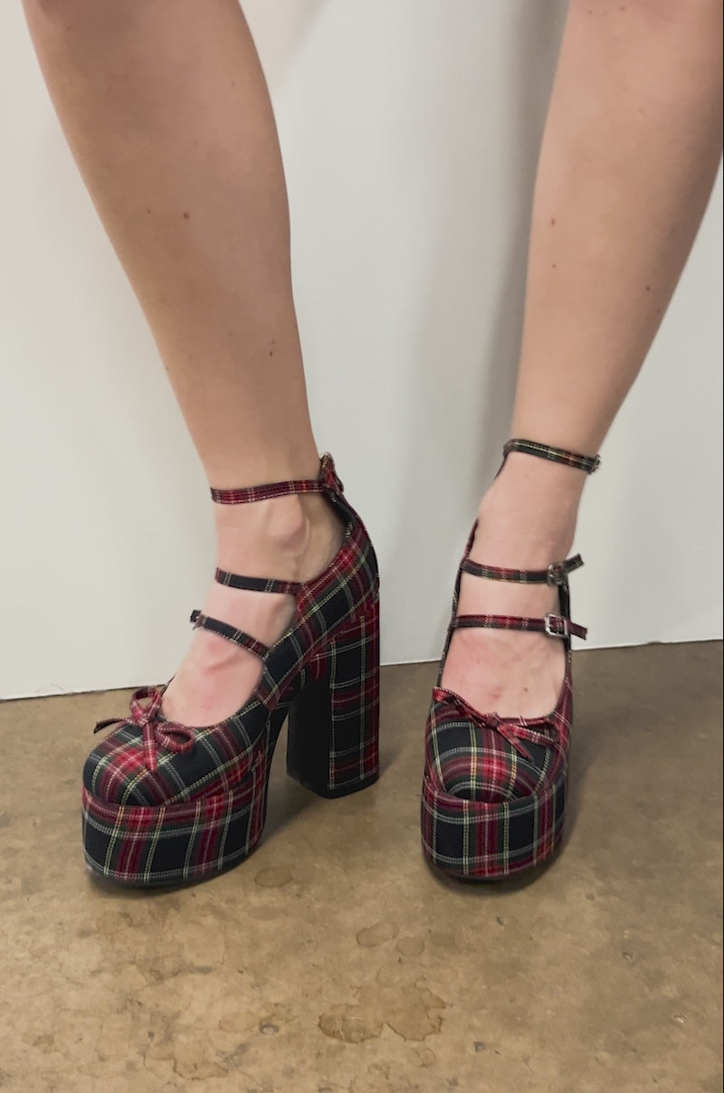 Video of person wearing the AZALEA WANG GEORGINA MULTI PLAID CHUNKY PUMP heels with ankle straps, standing against a white background and showing their bare legs from mid-thigh down.