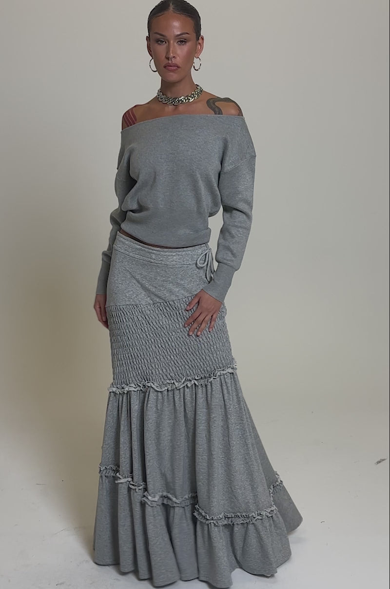 Video of woman modeling the IT ONLY GETS BETTER RUCHED MAXI SKIRT IN HEATHER GREY, styled with hoop earrings and a chunky necklace against a plain background.