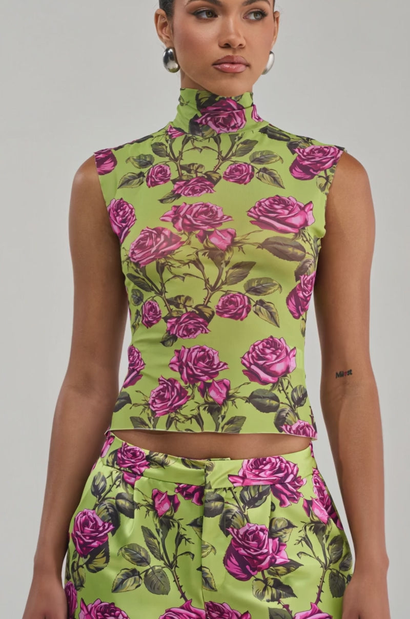 Video of a woman modeling the DOZEN ROSES MESH TOP IN CHARTREUSE, a sleeveless mock neck style in green with pink rose print. 