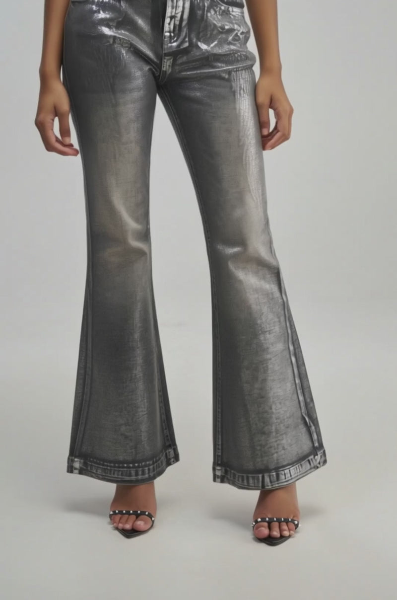 Video of a woman modeling the THE REAR VIEW WINGS DENIM—silver metallic jeans featuring angel wing detailing and a flared streetwear silhouette.