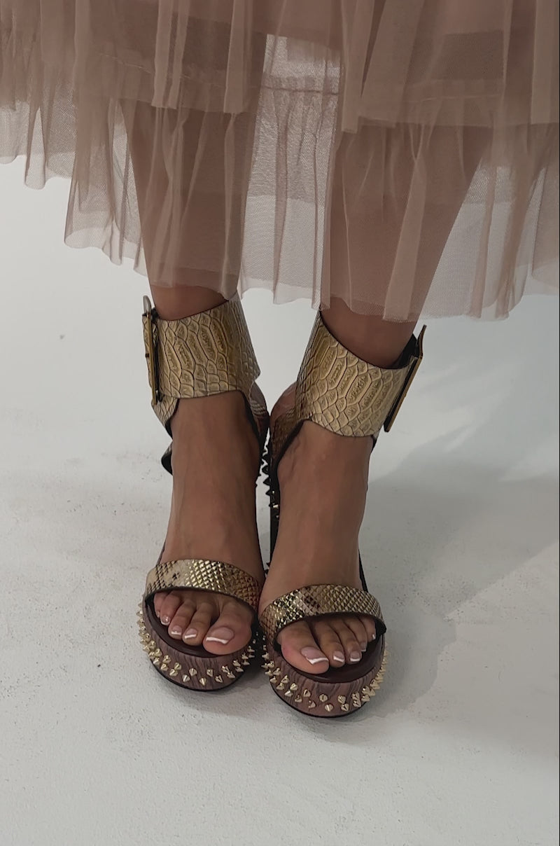 Video of woman modeling the AKIRA GOLD SLOANE BROWN STUD AND SNAKE WEDGE SANDALS