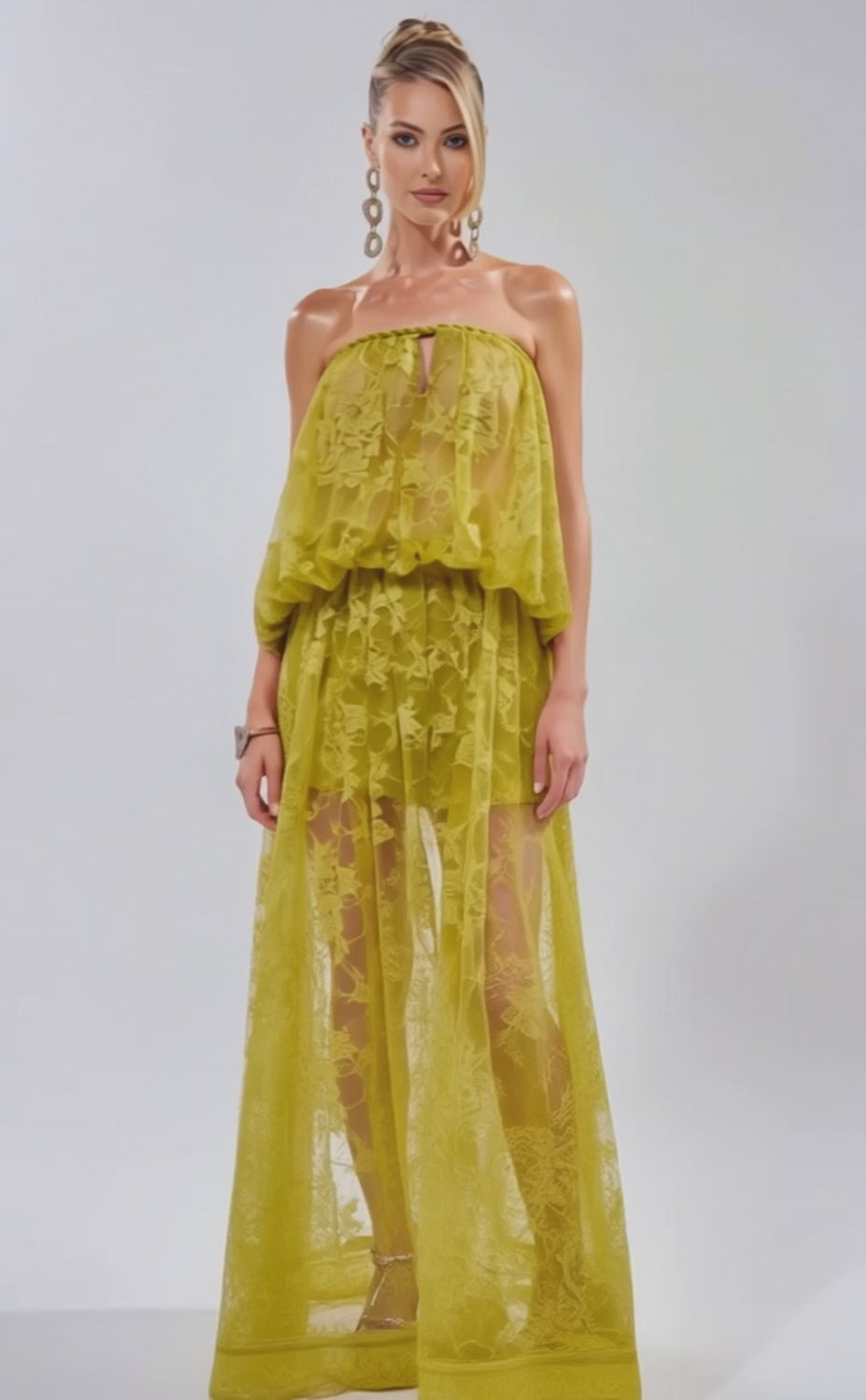 A video of a woman wearing the HANNAH LACE BLOUSE—a sheer, strapless yellow top with a loose, flowing silhouette. 