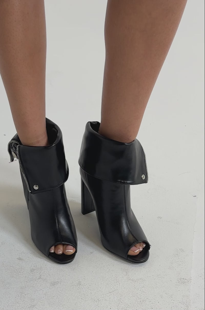 A video of a person wearing the YANIX BLACK PU SILVER HARDWARE CHUNKY HEEL BOOTIES.