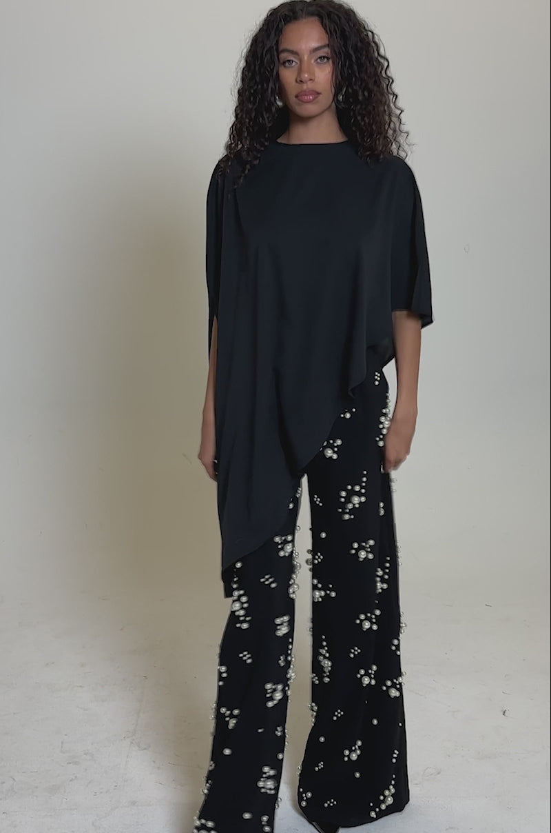 Video of woman modeling the SOMETHING DIFFERENT OVERSIZED ASYMMETRICAL TEE and black pearl-embellished pants