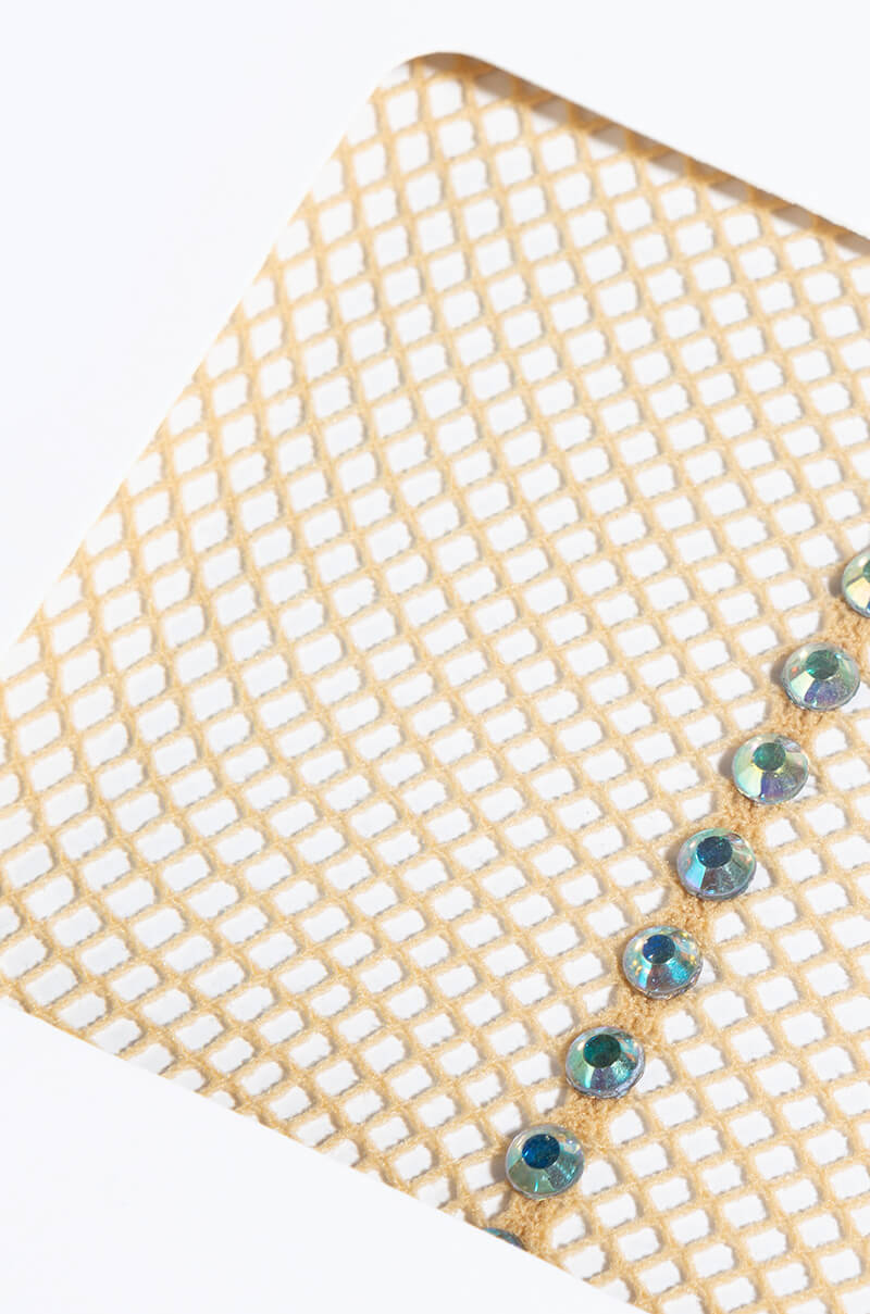 Close-up of the SINGLE RHINESTONE LINE TIGHT, showcasing a diamond-patterned mesh fabric in light beige. A row of small, round, iridescent rhinestones, reflecting shades of blue and green, is neatly lined up along one edge.