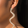 Close-up of a woman's ear adorned with a long, snake-shaped earring. The earring is silver with embedded rhinestones that add a sparkling effect. The earring dangles and curls in an upward-then-downward motion, creating a striking and elegant look. 

Product Name: SNEAKY SNAKE EARRINGS SILVER