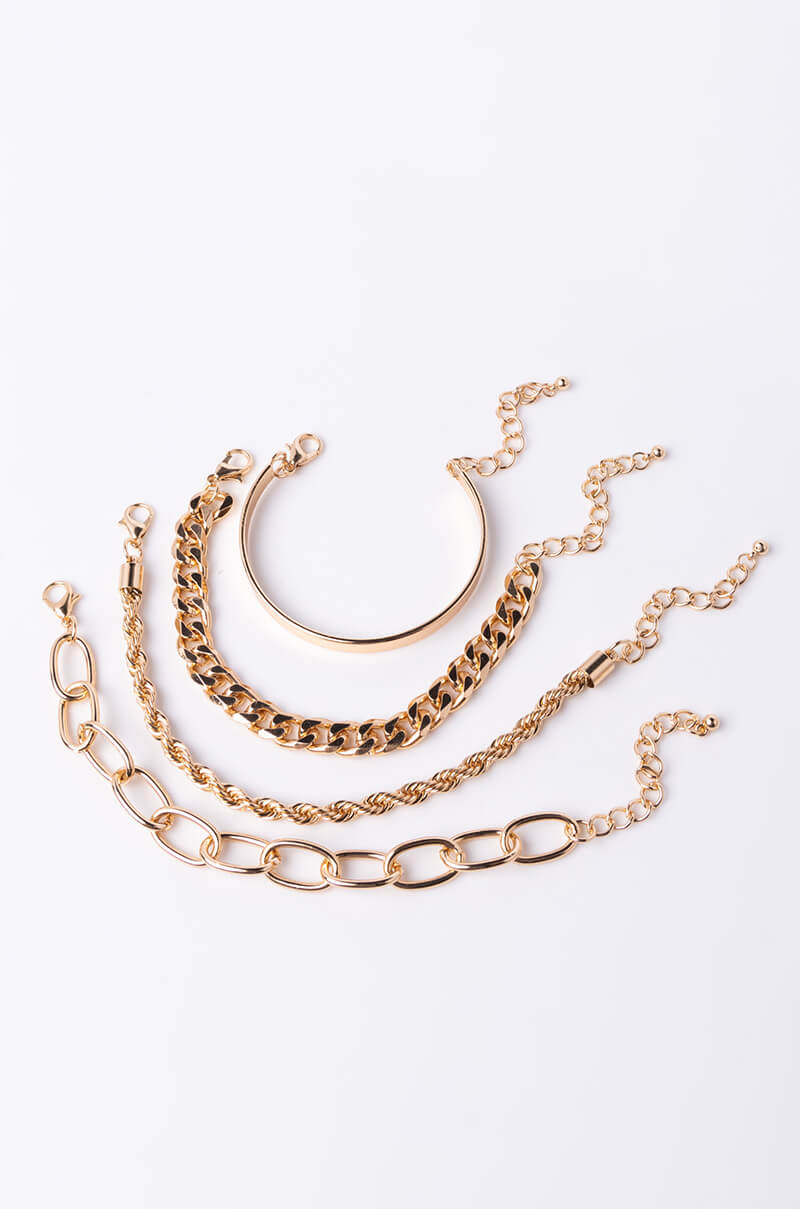 Four gold-tone bracelets from the SUMMER READY CHAIN BRACELET SET arranged on a white background. The top bracelet is a solid bangle with a chain, the second is a chunky chain, the third is a more delicate twisted chain, and the bottom one features large, elongated chain links.