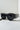 TELL ME NOTHING RHINESTONE SUNGLASSES ASSORTED feature an array of small, shimmering rhinestones along the top rim and temples of their black oversized frame. The dark-tinted lenses enhance the bold, glamorous style. These stunning sunglasses are showcased on a light-colored surface with a minimalist background.