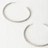 A pair of WAP BLING HOOP EARRINGS is displayed on a white background. These sparkling silver hoop earrings are adorned with small, shiny rhinestones, giving them a glittering appearance. They have a semi-circular shape and a slender design, perfect for an elegant look.